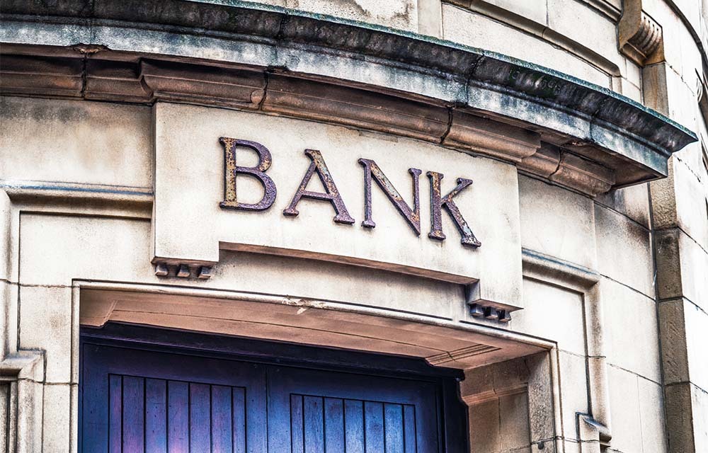 An old-fashioned bank sign on the exterior of a building.